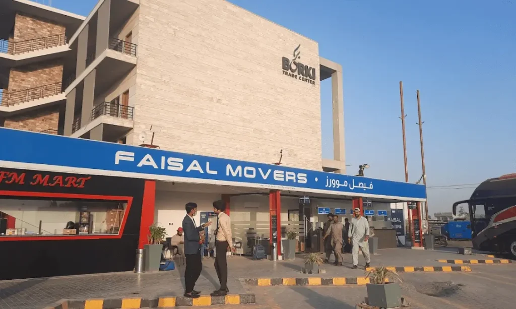 Faisal Movers terminal front with blue Faisal Movers board and FM Mart